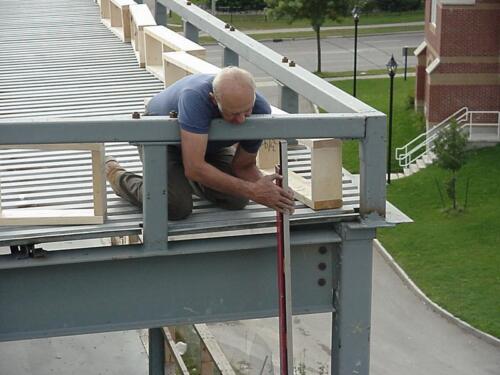 129-WorkerKneelingOnRoof-09-30-04